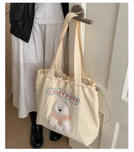 Detail der süßen Welpen-Plüschapplikation und Stickerei auf dem cremefarbenen Shopper