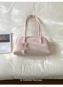 Detail of light pink shoulder bag with star charm and soft leather texture shown in a set
