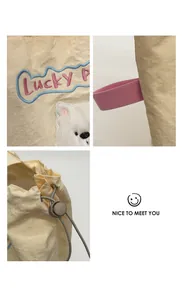 Detail von Lucky P Stickerei und Bärenaufnäher auf beiger Nylon-Tasche mit Kordelzug