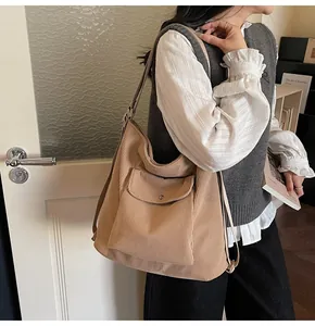 Detail of khaki corduroy shoulder bag with front flap pocket and adjustable strap
