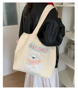 Detail der süßen Bärenstickerei und des Lucky Puppy Textes auf cremeweißer Segeltuchtasche