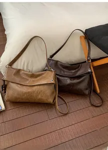 Detail of vintage crinkle leather tote bags with bead charms on wooden flooring