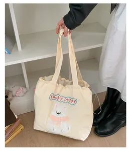 Detail der süßen weißen Welpen-Stickerei auf cremefarbener Canvas-Tasche mit Kordelzug