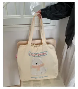 Detailansicht der cremefarbenen Canvas-Tasche mit Welpen-Stickerei und Kordelzug