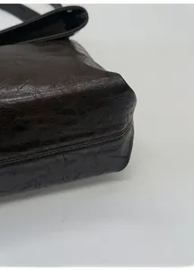 Detailed macro view of the reinforced thick base on a dark brown textured tote bag