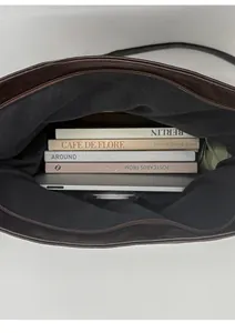 Internal view of large brown leather tote bag holding a laptop and four books