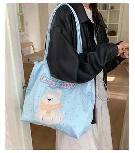 Detail einer hellblauen gepunkteten Segeltuchtasche mit süßer Hundestickerei
