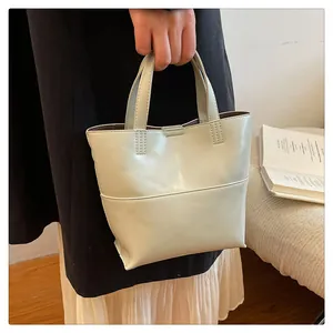 Detailed view of cream PU leather mini tote bag with structural stitching and top handle