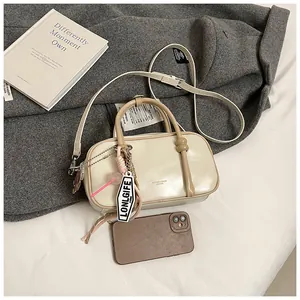 Gros plan du sac Boston crème avec poignées en cuir et étiquette sur manteau