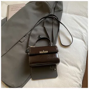 Mini chocolate brown crossbody bag detail with silver twist lock and retro leather texture