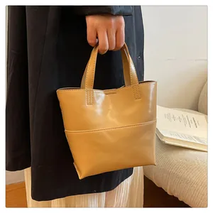 Close-up of a minimalist light brown tote bag with smooth leather finish and reinforced seams