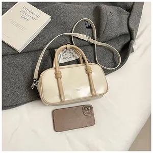 Sac Boston avec référence de taille smartphone sur manteau gris et bandoulière amovible