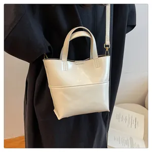Detail of minimalist cream PU leather tote bag with dual handles and thin shoulder strap
