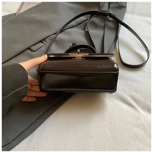 Macro detail of dark brown oil wax leather handbag with vintage metal clasp closure