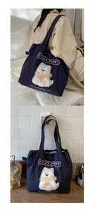 Detail einer blauen Canvas-Tasche mit Plüschwelpen-Patch und Stickerei-Verzierung