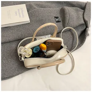 Vue intérieure du sac Boston crème montrant l'espace pour parfum, téléphone et maquillage