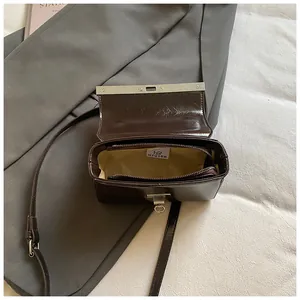 Minimalist dark brown glossy crossbody bag with internal zipper pocket and flap opening
