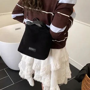 Sac seau vintage en daim noir avec logo en cuir et bandoulière amovible réglable
