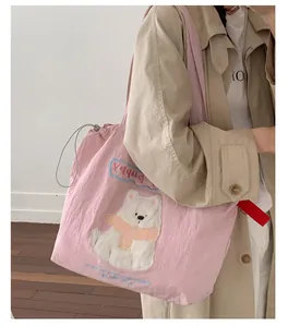 Nahaufnahme der rosa Nylon-Einkaufstasche mit Plüschbären-Aufnäher und Kordelzug