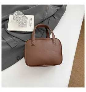 Detail of dark brown lychee grain leather texture and handle on a classic briefcase