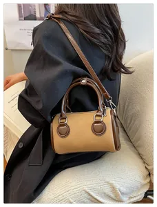 Detalle de un bolso Boston bicolor minimalista con correas de cuero marrón y cuerpo beige