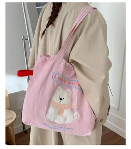 Rückansicht einer rosa Stofftasche mit Welpen-Print getragen über einem khakifarbenen Mantel