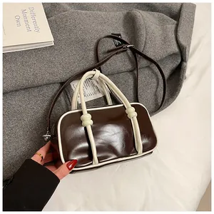 Vue détaillée du sac Boston en cuir ciré marron avec finitions contrastées beiges