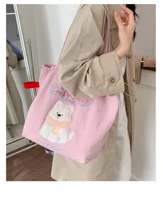 Nahaufnahme der süßen Bärenstickerei und des Lucky Puppy Schriftzugs auf pinker Tasche
