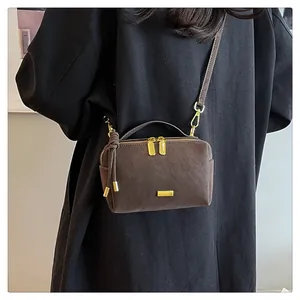 Detail of vintage dark brown Boston bag with matte leather finish and golden hardware