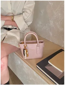 Nahaufnahme der hellrosa Mini-Handtasche mit runden Griffen und Logo-Aufdruck