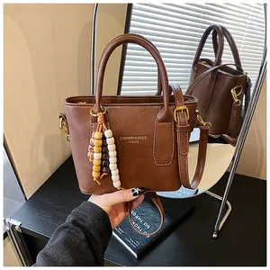 Detail der braunen Vintage-Eimertasche mit bunten Holzperlen und goldenen Metallbeschlägen