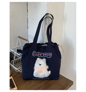 Detail der dunkelblauen Kordelzug-Tasche mit 3D-Stickerei eines Glückswelpen-Aufnähers