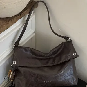 Dark brown faux leather tote bag with Korean lettering shown from a 45-degree angle