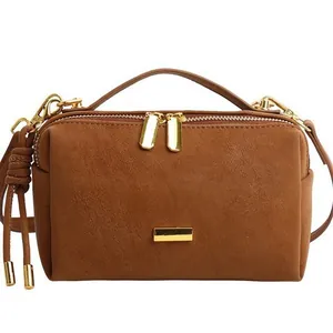 Retro brown suede Boston pillow bag with golden hardware and adjustable strap