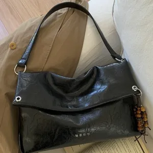 Vintage black leather tote bag with unique crinkle texture and wood bead tassel accessory
