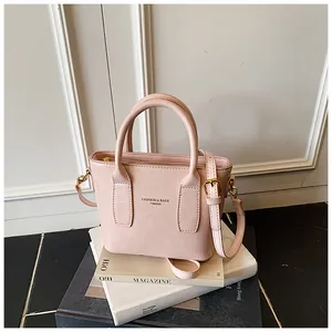 Nahaufnahme der rosa Kunstledertextur und goldener Beschläge der Eimerhandtasche