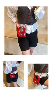 Dettaglio mini borsa rossa con pois e motivo a cavallo con tracolla sottile