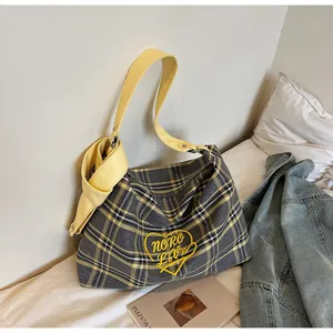 Detail of grey and yellow checkered tote bag with heart embroidery and yellow wide strap