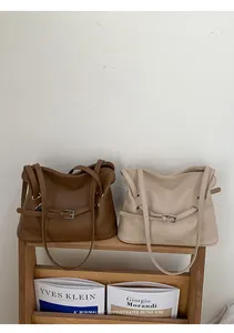 Detalle de bolsos tote en cuero fruncido marrón y beige con hebillas de cinturón decorativas