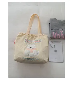 Detailansicht der gelben Canvas-Tasche mit Hunde-Stickerei und Kordelzugverschluss