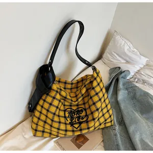 Close-up of yellow plaid canvas tote bag with heart embroidery and knotted PU strap