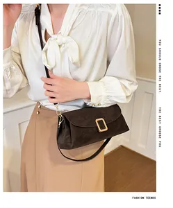 Detail of vintage coffee square bag with matte leather texture and gold metal buckle