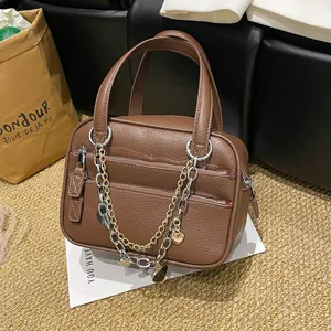 Brown litchi leather briefcase with layered zippers and gold chain heart pendant