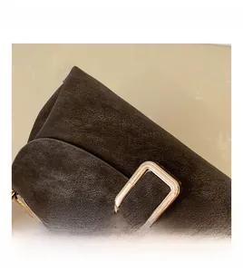 Detail of dark brown retro leather texture and large rectangular gold metal buckle