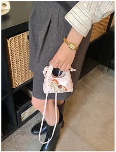 Dettaglio mini borsa rosa con pony patchwork colorato e manico decorato con nodi