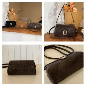 Detail of square vintage leather crossbody bags in black and brown with gold magnetic buckle