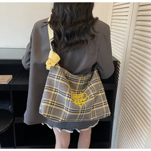 Macro shot of large plaid tote bag featuring yellow heart embroidery and woven texture