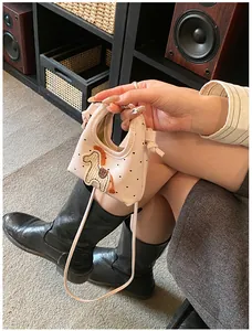 Dettaglio della mini borsa rosa con toppa a cavallo e stampa a cuori su tracolla