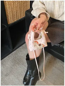 Mini borsa a tracolla rosa con ricamo a cavallo e pois neri mostrata nell'uso quotidiano