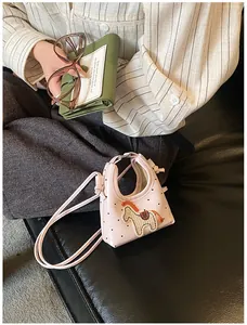 Dettaglio mini borsa rosa con stampe a cuore e ricamo a cavallo in stile cartone